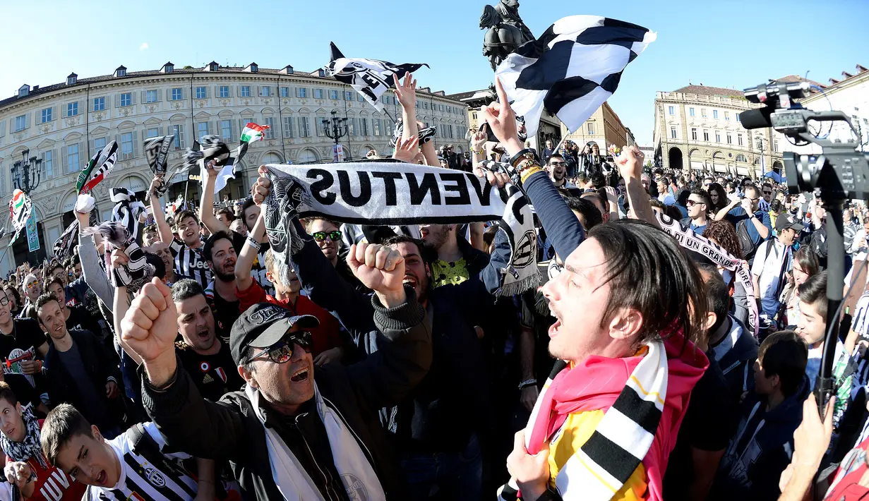Ribuan suporter Juventus berteriak merayakan kemenangan usai merebut gelar Serie A Italia di pusat kota Turin, Italia (25/4). Juventus berhak meraih gelar Scudetto mereka yang ke-34. (REUTERS/Giorgio Perottino)