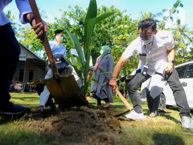 Corporate Secretary Bank BTN Ari Kurniaman (kanan) saat penanaman bibit pohon kelapa hibrida pandan wangi di Pantai Air Manis, Kota Padang, (7/01/2022). Bantuan ini merupakan bagian dari kegiatan Tanggung Jawab Sosial dan Lingkungan (TJSL) perseroan. (Liputan6.com/HO/BTN)