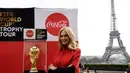Duta Besar FIFA World Cup 2018, Victoria Lopyreva berpose dengan trofi Piala Dunia dengan latar menara Eiffel selama FIFA World Cup Trophy Tour di Paris (20/3). Piala Dunia 2018 diselenggarakan 14 Juni dan 15 Juli 2018 di Rusia. (AFP Photo/Franck Fife)