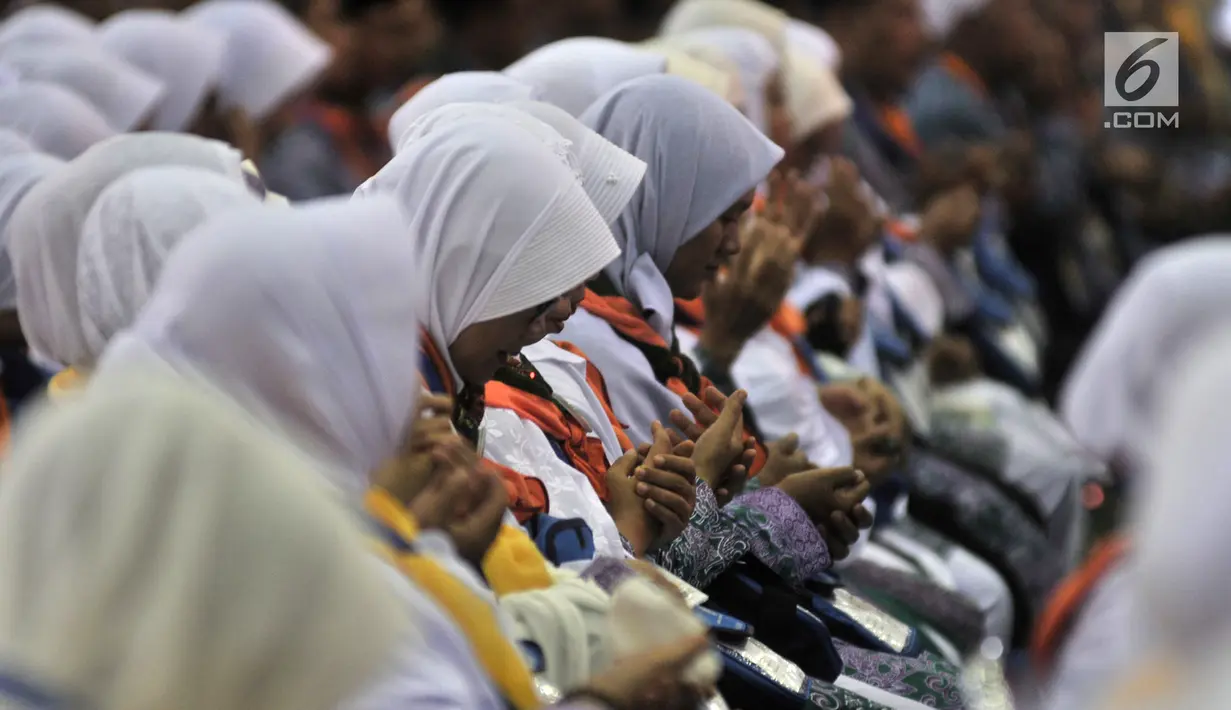 Calon jemaah haji Kloter 1 berdoa saat berkumpul di Asrama Haji Pondok Gede, Jakarta, Senin (16/7). Kloter 1 Embarkasi Jakarta-Pondok Gede akan diberangkatkan ke Arab Saudi pada Selasa (17/7). (Merdeka.com/Iqbal Nugroho)