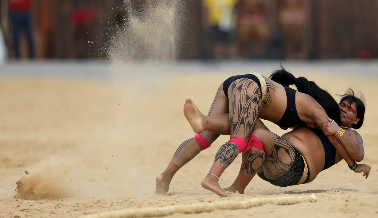 Dua wanita adat sedang bergulat dalam pertandingan yang disebut Huka Huka pada Olimpiade bagi Masyarakat adat, Palmas, Brasil, (30/10/2015). Sekitar 48 etnik yang akan terdiri atas empat ribu atlet ikut dalam Olimpiade ini. (REUTERS/Ueslei Marcelino)