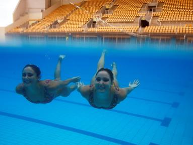Atlet renang indah Brasil, Maria Eduarda Miccuci (kanan) dan Luisa Borges beraksi dalam sesi foto jelang Olimpiade Rio 2016 di Rio Olympic Park, Rio de Janeiro, Brasil, (Reuters/Pilar Olivares)