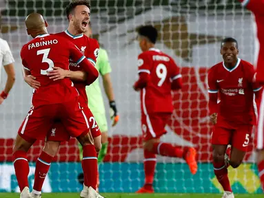 Penyerang Liverpool, Diogo Jota bersama rekan setimnya Fabinho merayakan gol ke gawang Arsenal pada pekan ketiga Liga Inggris di Anfield, Selasa dinihari WIB (29/9/2020). Tertinggal lebih dulu, Liverpool mampu membungkam Arsenal dengan skor 3-1. (Jason Cairnduff/Pool via AP)