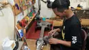 Pengrajin melakukan finishing pembuatan gitar di Syukey Guitars, Cirendeu, Ciputat Timur (3/4). Gitar ini tidak hanya dipasarkan di dalam negeri saja, tetapi juga dipasarkan hingga Amerika dan Eropa. (Merdeka.com/Arie Basuki)