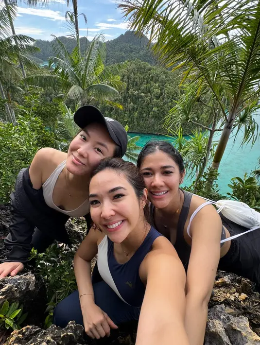Gisella, Naysila, dan seorang teman mereka dalam perjalanan mendaki mendaki tebing berbatu dengan latar belakang pemandangan spektakuler dari Wayag Island, Raja Ampat. Senyumnya yang lebar mencerminkan kepuasan dan kebahagiaan setelah mencapai puncak dengan usaha yang tidak mudah. (Liputan6.com/IG/@gisel_la)