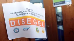 Kertas bertuliskan "Disegel" terpasang di pintu masuk ruangan ujian nasonal berbasis komputer (UNBK) SMA 12 Cilenggang, Serpong, Senin (9/4). UNBK sekolah menengah atas (SMA) dan madrasah aliyah (MA) berlangsung 9-12 April 2018. (Merdeka.com/Arie Basuki)