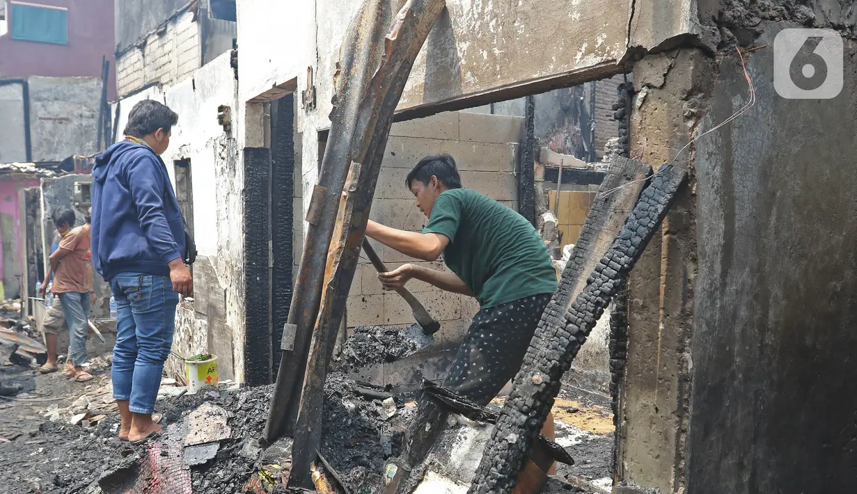 Warga melihat sisa permukiman yang terbakar di Jalan Keadilan Dalam, Taman Sari, Jakarta Barat, Senin (19/4/2021). Kebakaran permukiman padat tersebut mengakibatkan sebanyak 200 rumah hangus terbakar dan sekitar 1.000 warga terpaksa mengungsi. (Liputan6.com/Herman Zakharia)
