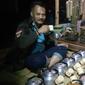Salah satu pengunjung tengah menikmati hidangan teh hangat dalam festival Nyaneut di Garut (Liputan6.com/Jayadi Supriadin)