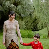Asmirandah tampil elegan mengenakan kebaya warna nude dengan aksen kancing depan dipadukan bawahan kain batik lilit. Putrinya Chloe pun menggemaskan tampil dengan kebaya brokat merah dipadukan kain batik serasi dengan sang mamah. [@asmirandah89]