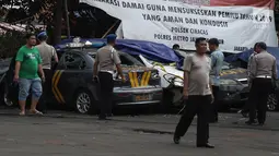 Petugas Ditlantas Polda Metro Jaya membawa mobil dinas polisi di Mapolsek Ciracas, Jakarta, Rabu (12/12). Sejumlah mobil yang rusak tersebut akan dibawa ke Polda Metro Jaya. (Liputan6.com/Herman Zakharia)