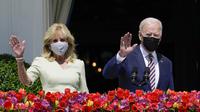 Presiden Joe Biden bersama Ibu Negara Jill Biden melambaikan tangan dari balkon Ruang Biru, Gedung Putih, Washington, Amerika Serikat, Senin (5/4/2021). Gedung Putih kembali meniadakan tradisi Easter Egg Roll menyusul pandemi COVID-19 yang sedang berlangsung. (AP Photo/Evan Vucci)
