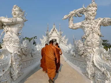 Biksu saat melakukan tur di Wat Rong Khun atau kuil putih di Provinsi Chiang Mai, Thailand, Jumat (4/3). Kuil Putih dirancang oleh seniman visual Thai Chalermchai Kositpipat. (REUTERS / Jorge Silva)