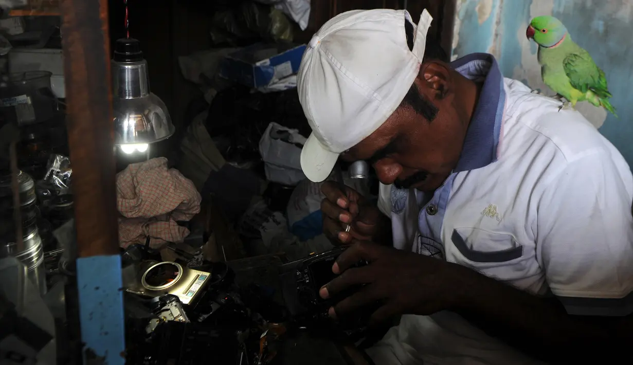 Joseph Sekar saat memperbaiki kamera di Chennai, India, Jumat (17/3). Pekerjaan sehari-hari Joseph Sekar adalah menerima jasa perbaikan kamera. (AFP PHOTO / ARUN Sankar)