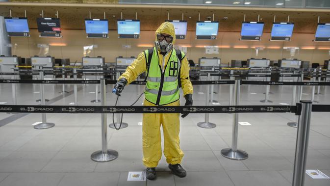 Seorang pekerja mendisinfeksi area check-in dalam Bandara Internasional El Dorado di Bogota, Kolombia, Senin (31/8/2020). Presiden Kolombia Ivan Duque mengizinkan lebih banyak penerbangan domestik mulai September. (Juan BARRETO/AFP)