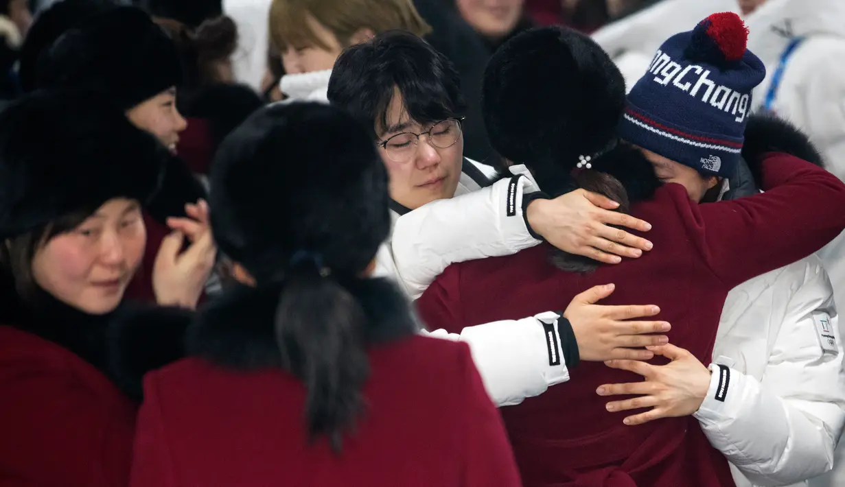 Pemain tim hoki wanita Korea Utara memeluk rekannya asal Korea Selatan saat akan kembali ke negaranya usai mengikuti Olimpiade Pyeongchang di Olympic Village, Gangneung, Korea Selatan, Senin (26/2). (Yun Dong-jin/Yonhap via AP)
