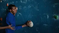 Seorang remaja tuna netra bernama Dominic Hezron mencoba menyentuh papan panjat dinding saat acara pelatihan di Nairobi, Kenya (15/3). Latihan panjat dinding tuna netra ini diselenggarakan oleh NPO Monkey Magic. (AFP/Yasuyoshi Chiba)