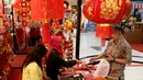 Pengunjung membeli pernak-pernik Imlek di atrium Lippo Mall Puri, Jakarta, Jumat (01/2). Kegiatan menyambut Tahun Baru Imlek yang mengusung tema Let’s Gong Xi berlangsung hingga 28 Februari 2019. (Liputan6.com/Fery Pradolo)