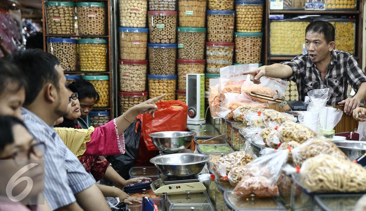 Suasana pembelian kue di salah satu toko di di Pasar Jatinegara, Jakarta, Senin (27/6). Alasan warga membeli panganan khas lebaran di toko kue karena lebih praktis dan terjangkau harganya. (Liputan6.com/Faizal Fanani)