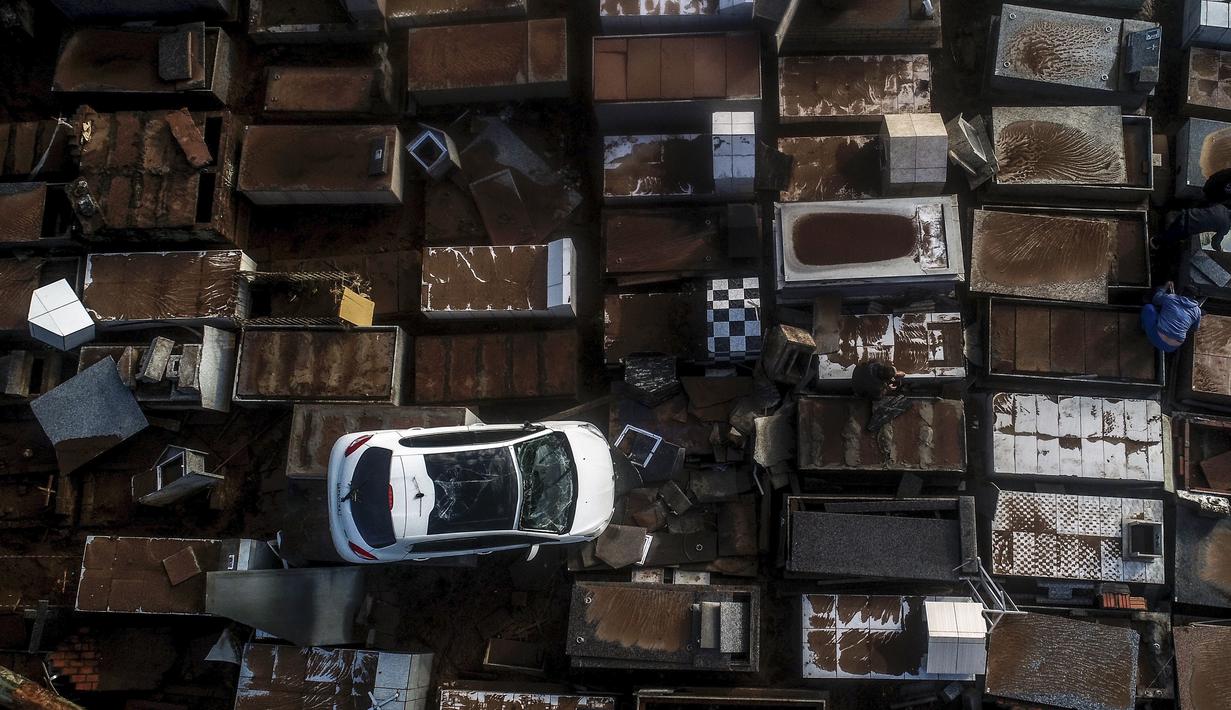 Sebuah kendaraan rusak tergeletak di pemakaman setelah hujan lebat di Caraa, negara bagian Rio Grande do Sul, Brasil, Minggu, 18 Juni 2023. (AP Photo/Wesley Santos)