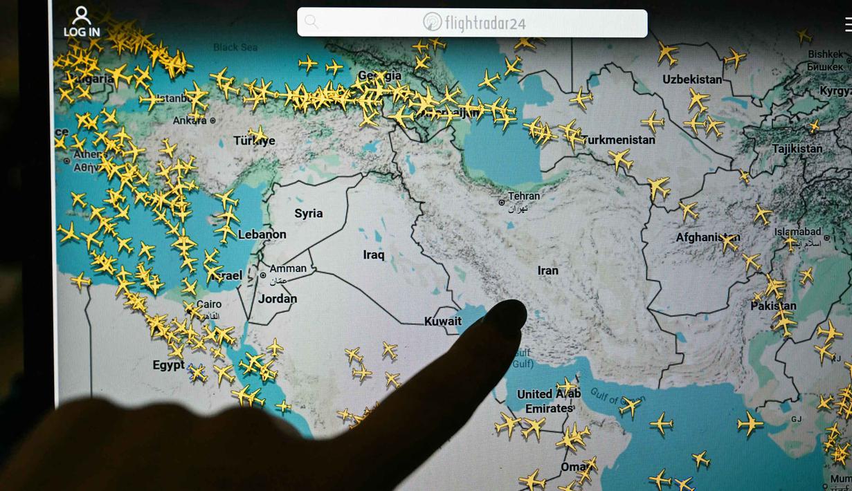 Per 1 Maret 2026, wilayah udara Iran dan Irak ditutup sepenuhnya untuk penerbangan sipil menyusul eskalasi militer besar-besaran Amerika Serikat dan Israel. Tampak dalam foto, seseorang menunjuk ke halaman di situs web Flightradar 24 yang menunjukkan penerbangan sipil menghindari wilayah udara Iran dan Irak, di Paris pada Minggu 1 Maret 2026. (Anna KURTH/AFP)