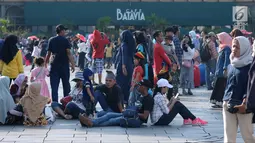 Warga duduk beristirahat di pelataran Museum Fatahillah, Jakarta, Selasa (19/6). Kemudahan transportasi dan biaya yang murah menjadikan kawasan ini sebagai lokasi favorit warga untuk menghabiskan waktu libur. (Liputan6.com/Helmi Fithriansyah)