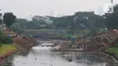 Alat berat excavator mengeruk tanah dan lumpur pada proyek pengendalian banjir sodetan Ciliwung di  Sungai Kanal Banjir Timur, Cipinang, Jakarta, Jumat (26/5/2023). (merdeka.com/imam buhori)
