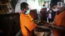 Tersangka memusnahkan barang bukti narkotika di Jakarta, Rabu (24/8/2022). Tersangka dan barang bukti yang disita berasal dari operasi pada periode 25 Mei 2022 hingga 20 Juli 2022. (Liputan6.com/Faizal Fanani)