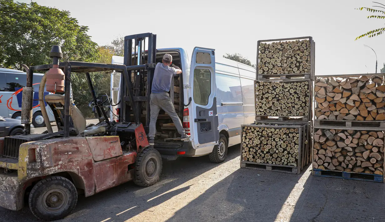 Seorang pedagang kayu bakar memasukkan palet ke dalam mobil van di luar Chisinau, Moldova, 15 Oktober 2022. Krisis energi yang melanda Eropa karena dipicu pemotongan aliran gas alam oleh Rusia di tengah perangnya melawan Ukraina telah memaksa beberapa orang untuk beralih ke kayu bakar untuk menghangatkan diri dalam cuaca yang beranjak dingin. (AP Photo/Aurel Obreja)