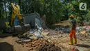 Petugas UPK Badan Air DLH Provinsi DKI Jakarta dibantu alat berat memperbaiki tembok Kali Krukut yang jebol di Jalan Taman Kemang, Jakarta, Selasa (23/2/2021). Jebolnya tembok tersebut mengakibatkan kawasan kemang dan sekitarnya terendam banjir pada 20 Februari 2021. (Liputan6.com/Faizal Fanani)
