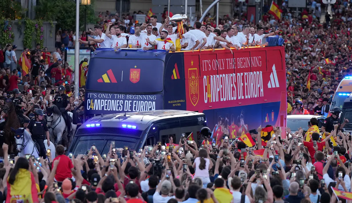 <p>Sejumlah pemain timnas Spanyol merayakan kemenangan saat diarak menggunakan bus terbuka menuju Cibeles Square saat perayaang kemenangan Euro 2024 di Madrid, Spanyol, Senin (15/07/2024) waktu setempat. (AFP/Cesar Manso)</p>