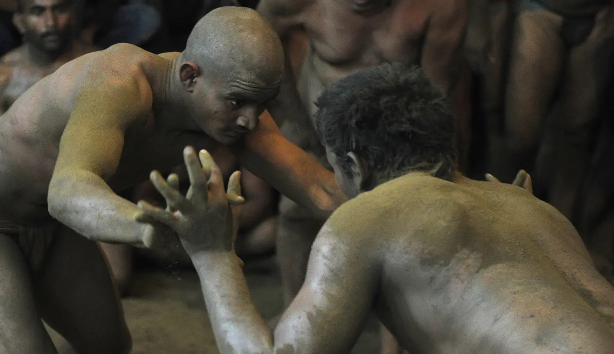 Dua pegulat bersiap melakukan pertandingan gulat tradisional di festival Nag Panchami di Allahabad, India, (7/8). Festival ini diadakan selama musim hujan dengan doa dan upeti untuk ular. (AFP PHOTO/SANJAY Kanojia)