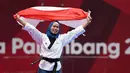 Atlet taekwondo putri Indonesia, Rosmaniar Defia berlari membawa bendera Merah Putih usai mengalahkan Marjan Salahshouri asal Iran pada partai final poomsae individu Asian Games 2018 di Jakarta, Minggu (19/8). (ANTARA FOTO/INASGOC/Darmawan/INP/18)