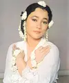 Suzzanna&nbsp; dikenal memiliki ciri khas mengenakan melati, seperti foto ini memadukan kebaya putih dengan aksesori melati di lengan dan sanggul rambutnya.&nbsp;[@suzzannaofficial]