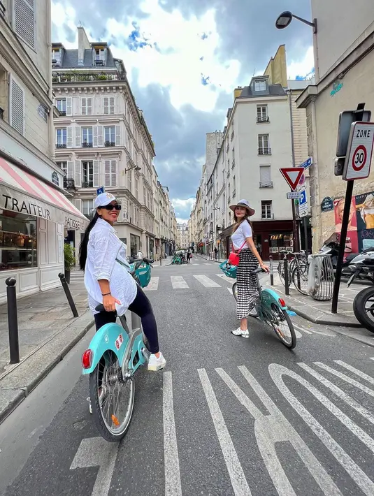 Luna Maya bersama temannya saat bersiap berkeliling kota Paris menggunakan sepeda. Ia tampil cantik mengenakan Kaos dan topi putih dengan membawa tas Hermes. (Instagram/lunamaya)