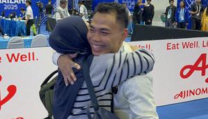 Weightlifter andalan Indonesia, Eko Yuli Irawan, mendapat pelukan dari sang istri, Masitah, setelah meraih medali perunggu di SEA Games 2025. Bertanding di Chon Buri Physical Education School, Chonburi, pada Minggu (14/12/2025) sore WIB, Eko kalah bersaing dari atlet Thailand dan Malaysia. (Bola.com/Muhammad Adi Yaksa)