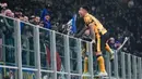 Pemain Inter Milan, Lautaro Martinez, melakukan selebrasi memanjat pagar setelah mencetak gol ke gawang Genoa dalam laga Serie A 2024/2025 giornata 26 yang dihelat di Giuseppe Meazza, Minggu (23/2/2025) dini hari WIB. (AP Photo/Luca Bruno)