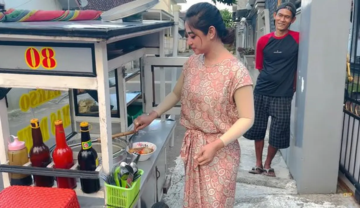 Pedangdut Dewi Perssik sedang membuat sendiri bakso yang dijual di depan rumah orangtuanya. Dewi Perssik memang sedang berada di kampung halamannya di Jember. (Youtube/Dewi Perssik)