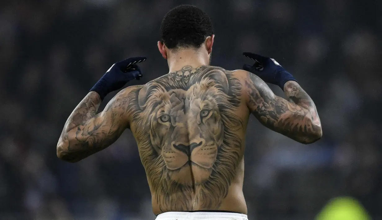 Penyerang Memphis Depay menunjukkan tato Singanya usai mencetak gol ke gawang PSG pada lanjutan Liga Prancis di stadion Grupama, Decines-Charpieu (21/1). Gol eks striker Manchester United ini membawa Lyon menang 2-1 atas PSG. (AFP Photo/Jeff Pachoud)