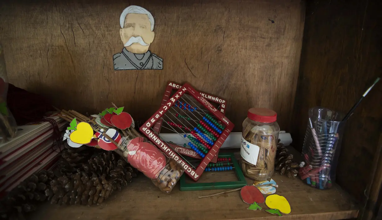 Bahan sekolah yang tidak terpakai tergeletak pada rak sementara gambar Presiden Meksiko tahun 1848-1876 Jenderal Porfirio Díaz terpasang pada dinding di sebuah sekolah di Nuevo Yibeljoj, Chiapas, Meksiko, 11 September 2020. (AP Photo/Eduardo Verdugo)