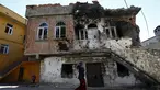 Seorang wanita berjalan melewati bangunan yang rusak akibat konflik antara Militer Turki dan Militan Kurdi di provinsi Diyarbakir, Turki, (7/12). Konflik ini telah terjadi puluhan tahun. (REUTERS/Murad Sezer)