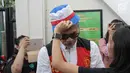 Putri terdakwa kasus penyalagunaan narkoba Tio Pakusadewo, Patricia memakaikan topi ke kepala ayahnya sebelum sidang lanjutan di PN Jakarta Selatan, Kamis (12/7). Sidang beragendakan pembacaan duplik atas replik dari JPU. (Liputan6.com/Faizal Fanani)