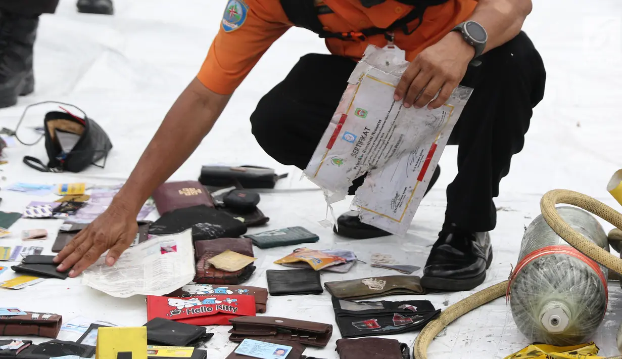 Petugas mengecek dan mengidentifikasi barang temuan yang diduga milik penumpang pesawat Lion Air JT 610 di Pelabuhan JICT 2, Jakarta, Selasa (30/10). Sebelumnya, pesawat Lion Air JT-610 jatuh diperairan Kerawang. (Liputan6.com/Helmi Fithriansyah)