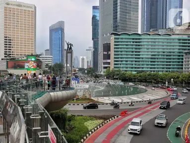 Sejumlah kendaraan bermotor melintas di kawasan Bundaran Hotel Indonesia, ruas Jalan MH Thamrin, Jakarta, Minggu (13/4/2025). (Liputan6.com/Angga Yuniar)