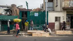 Mr. Jean bersama timnya membuat peti mati murah di jalan, padahal kegiatan ini dilarang di jalan raya umum, di Antananarivo, Madagaskar, Rabu (14/4/2021). Peti mati dari kayu pinus yang diproduksi selama satu jam tersebut dijual antara Rp 350ribu hingga Rp 820ribu. (RIJASOLO/AFP)