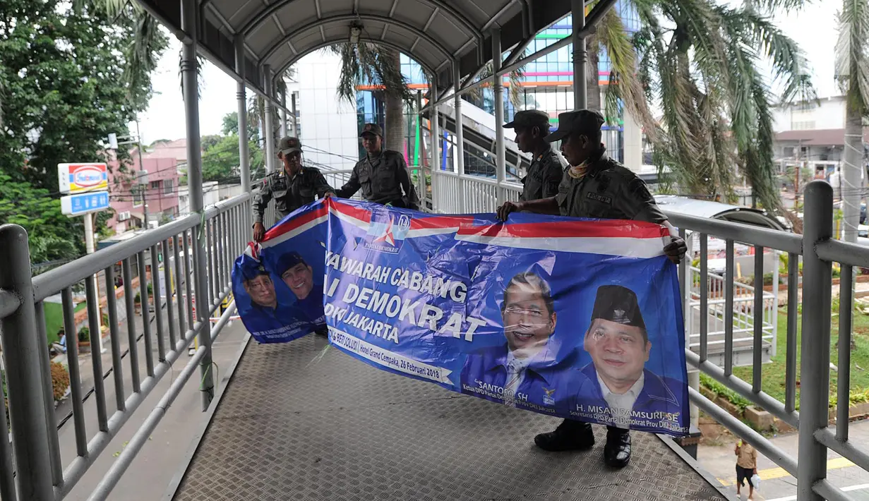 Petugas Satpol PP membongkar spanduk parpol yang dipasang di Jalan Letjen Suprapto, Cempaka Putih, Jakarta (21/3). Panwaslu Cempaka Putih menertibkan spanduk tersebut karena melanggar UU Nomor 7 Tahun 2017 tentang Pemilihan Umum. (Merdeka.com/Arie Basuki)