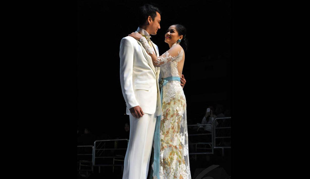 Pasangan Christian Sugiono dan Titi Kamal membawakan karya Anne Avantie yang betema putih, Jakarta, (3/9/14). (Liputan6.com/Panji Diksana)