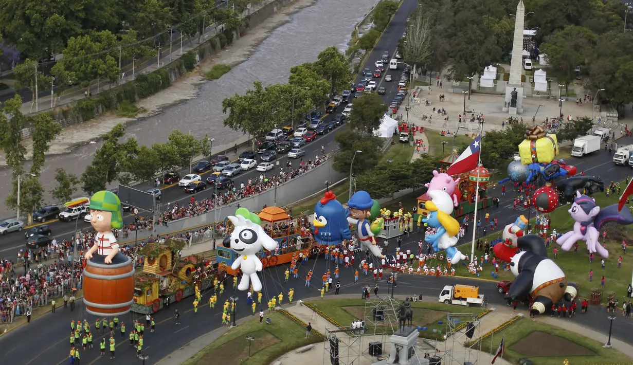 Parade balon karakter kartun meramaikan jalanan kota Santiago di Chile, (13/12). Kegiatan ini untuk menyambut Natal yang akan jatuh sebentar lagi. (REUTERS/Pablo Sanhueza)