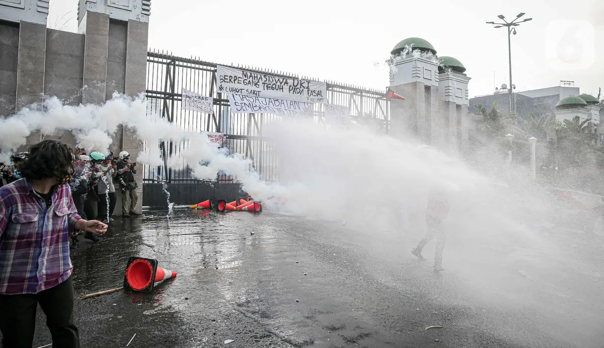 Polisi menembakkan water canon dan gas air mata ke arah para pengunjuk rasa di depan pintu gerbang gedung DPR RI, Jakarta, Senin (11/4/2022). Situasi mulai memanas akibat sejumlah pengunjuk rasa melempari petugas dengan berbagai benda lainnya. (Liputan6.com/Faizal Fanani)