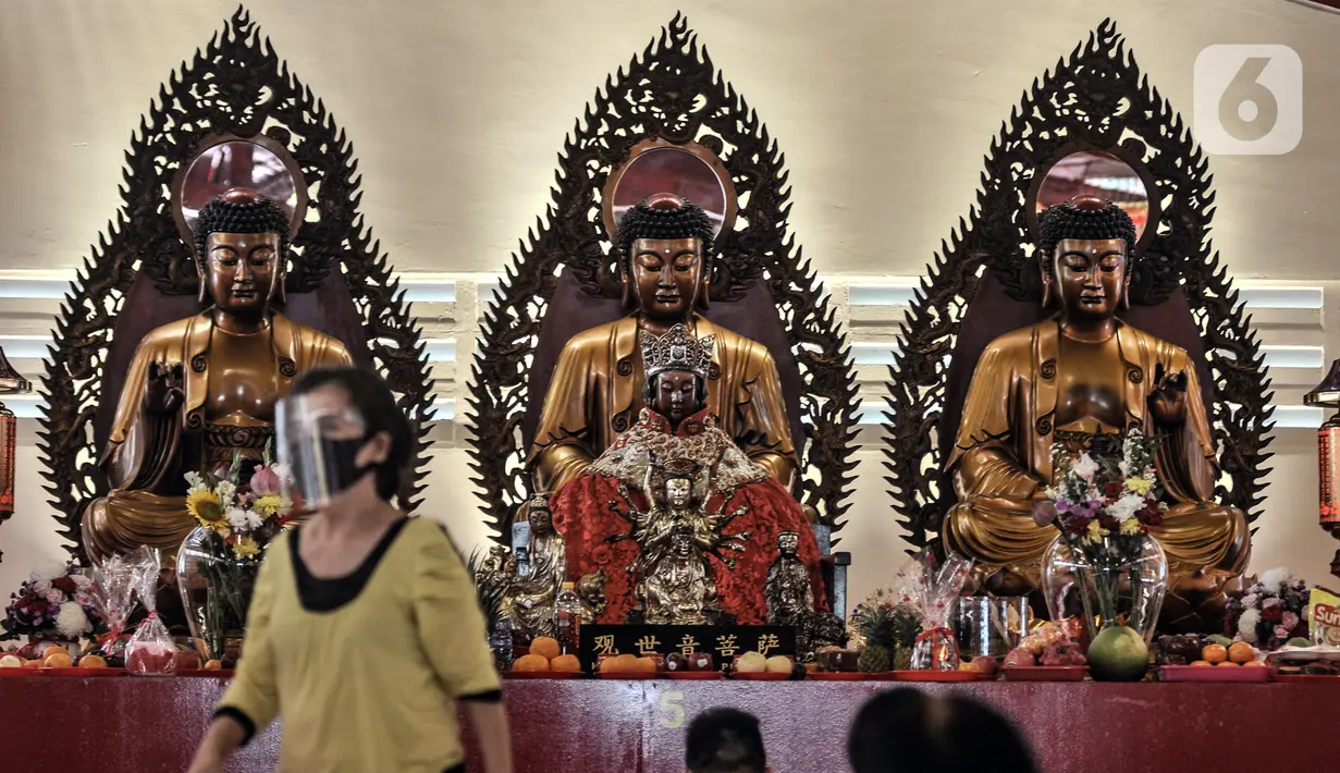 Warga keturunan Tionghoa mengenakan faceshield dan masker saat sembahyang malam Tahun Baru Imlek 2572 di klenteng kawasan Petak Sembilan, Glodok, Jakarta, Kamis (11/2/2021). Pihak klenteng juga memberikan sistem nomor antrean pada sembahyang malam Imlek kali ini. (merdeka.com/Iqbal S. Nugroho)