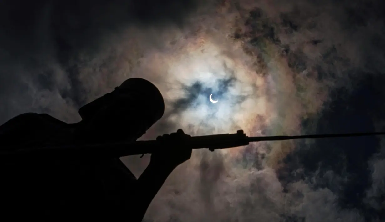 Pemandangan gerhana matahari cincin dengan latar belakang monumen Askari di Dar es Salaam, Tanzania, Kamis (1/9). Beberapa kota di luar negeri menjadi saksi dari gerhana Matahari cincin alias solar eclipse ini. (AFP PHOTO/Daniel Hayduk)